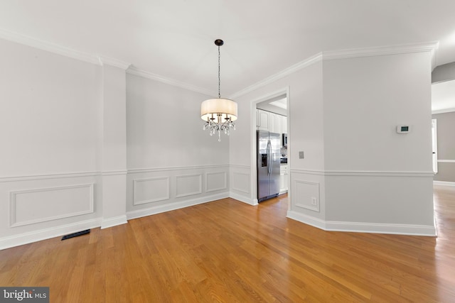 14 Osprey Ln, Bayville, NJ 08721 - empty room featuring a chandelier, light wood-style floors, ornamental molding, and a wainscoted wall