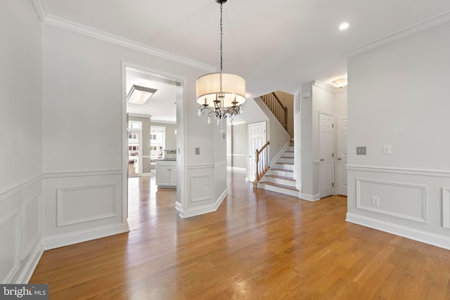 14 Osprey Ln, Bayville, NJ 08721 - unfurnished dining area featuring a decorative wall, stairs, a chandelier, crown molding, and light wood finished floors
