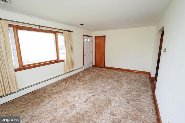 407 Elizabeth St, Georgetown, DE 19947 - carpeted spare room featuring a baseboard heating unit, arched walkways, and baseboards