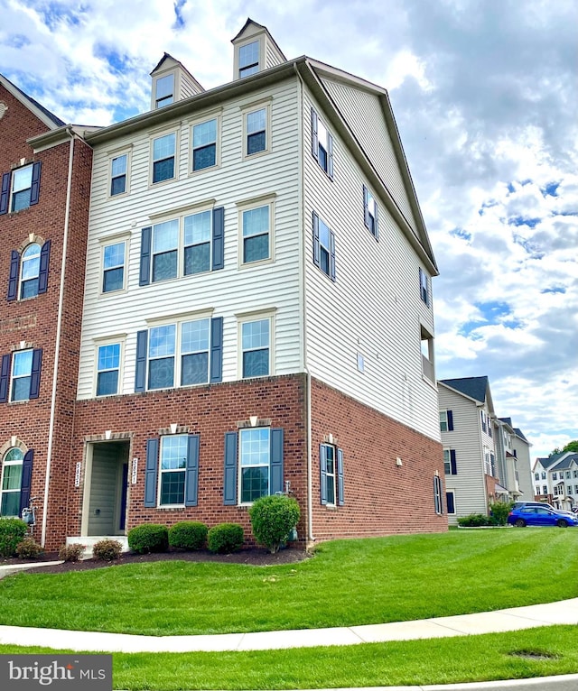 view of front of property featuring a front lawn and brick siding