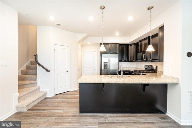 5831 Rochefort St, Ijamsville, MD 21754 - kitchen featuring stainless steel appliances, a sink, a peninsula, light stone countertops, and recessed lighting