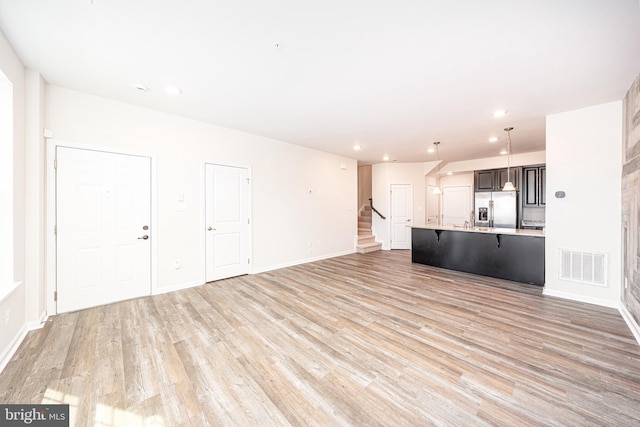 5831 Rochefort St, Ijamsville, MD 21754 - unfurnished living room featuring light wood-style floors, stairs, recessed lighting, and baseboards