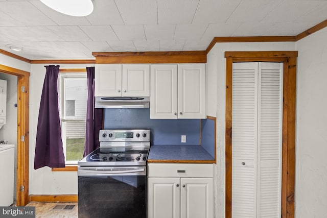 kitchen with electric range, under cabinet range hood, stacked washer and clothes dryer, crown molding, and white cabinetry
