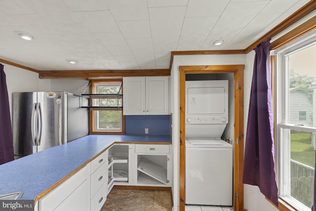 clothes washing area featuring stacked washing machine and dryer, ornamental molding, and recessed lighting