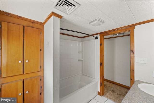 full bathroom featuring tile patterned floors, tub / shower combination, crown molding, baseboards, and vanity