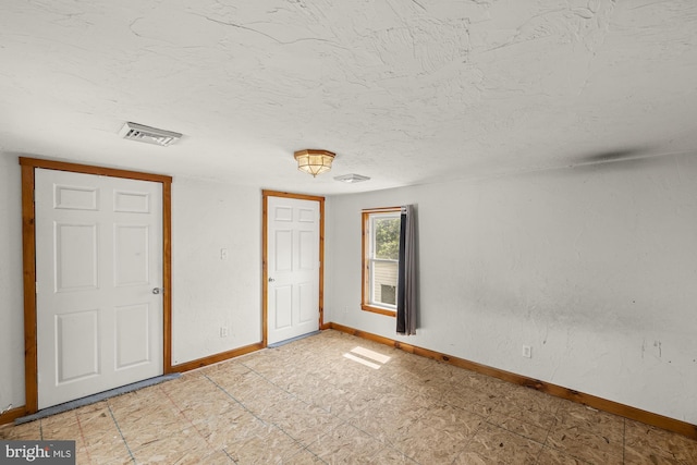 entrance foyer with baseboards and a textured ceiling