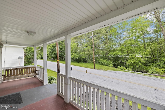 wooden terrace with a porch and view of scattered trees