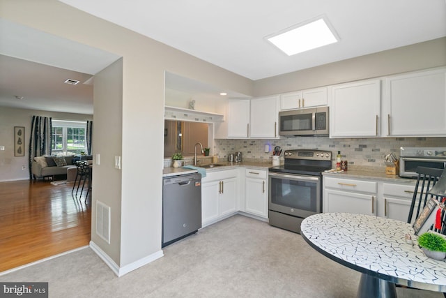 9642 Lambeth Ct, Columbia, MD 21046 - kitchen with appliances with stainless steel finishes, a sink, backsplash, and white cabinets