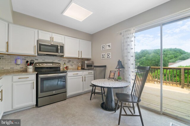 9642 Lambeth Ct, Columbia, MD 21046 - kitchen with stainless steel appliances, backsplash, white cabinets, and light colored carpet