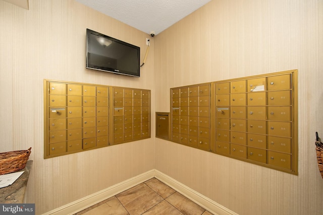 view of home's community with mail area, wallpapered walls, and a textured ceiling