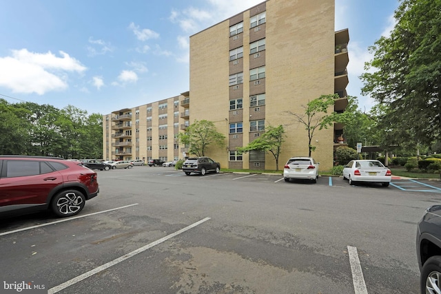 view of apartment building / complex with uncovered parking