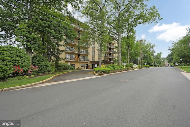 view of asphalt street featuring curbs