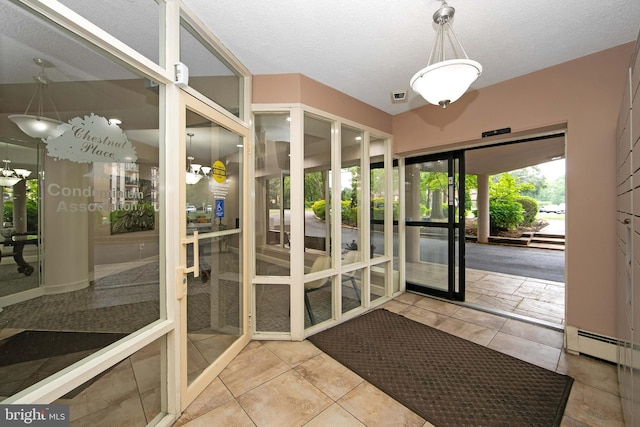 entryway with a baseboard heating unit and a textured ceiling