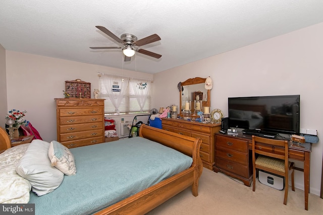 bedroom featuring light colored carpet and a ceiling fan