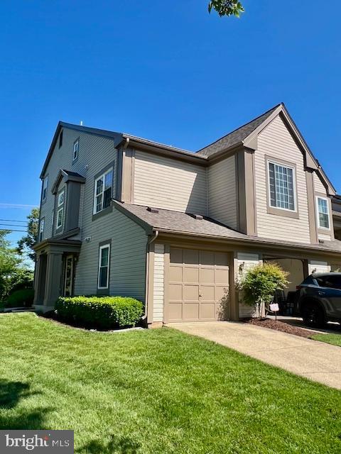view of home's exterior featuring an attached garage, driveway, and a yard