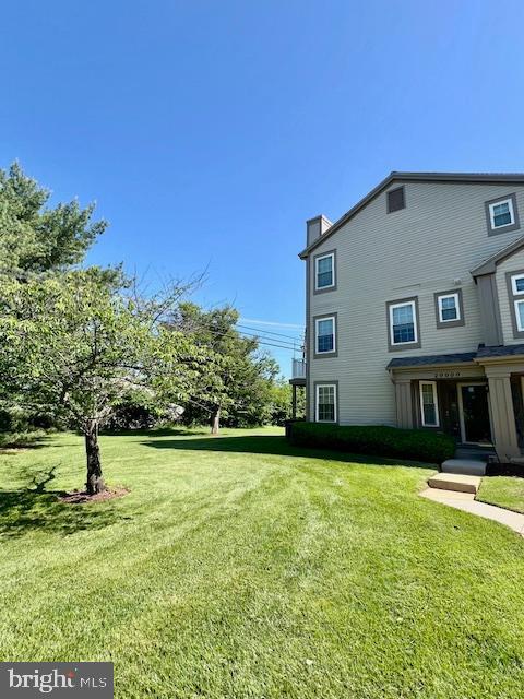 view of home's exterior with a yard and a chimney