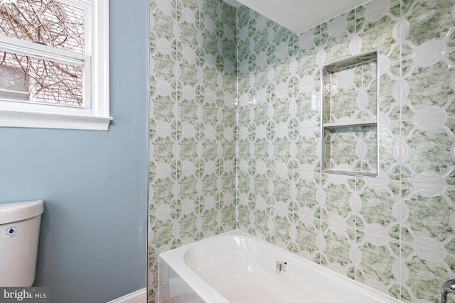 full bath featuring toilet and baseboards