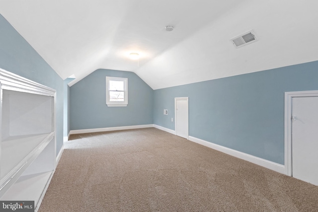 additional living space featuring carpet flooring, lofted ceiling, and baseboards