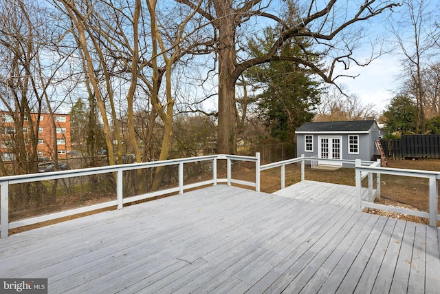 wooden terrace featuring an outdoor structure, a fenced backyard, and french doors