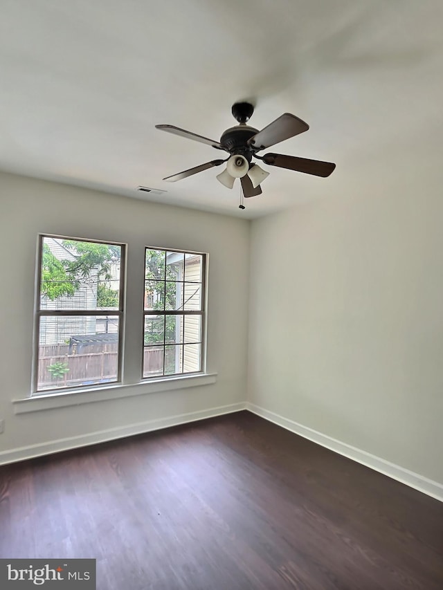 unfurnished room with dark wood-style flooring, baseboards, and a ceiling fan