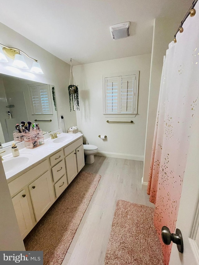 128 Eagle Rd, Dillsburg, PA 17019 - bathroom with wood finished floors, toilet, and double vanity