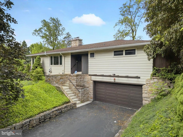 413 Wilton St, Harrisburg, PA 17109 - ranch-style home with stone siding, an attached garage, asphalt driveway, a chimney, and stairs