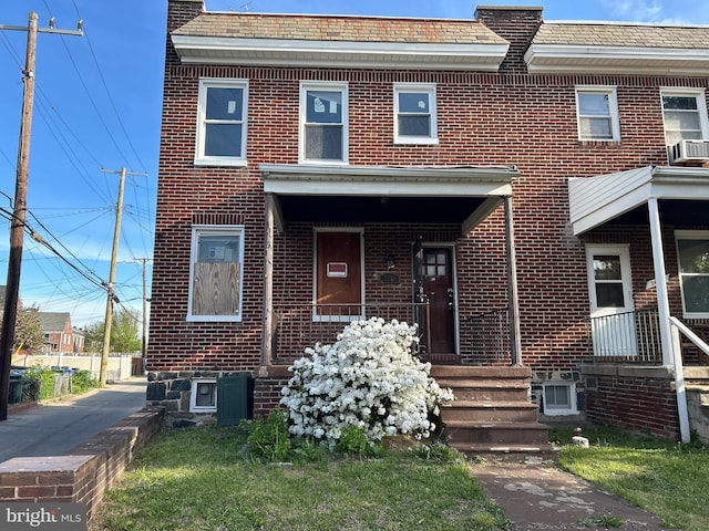 view of property featuring brick siding and cooling unit