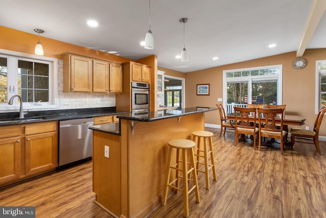 1733 Lockhart St, Toms River, NJ 08757 - kitchen featuring appliances with stainless steel finishes, a sink, vaulted ceiling, wood finished floors, and a breakfast bar