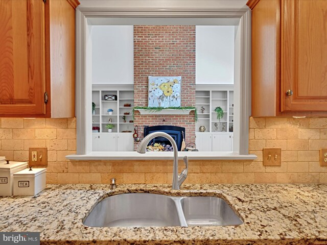 320 N Ridge Rd, Reinholds, PA 17569 - kitchen featuring a sink, tasteful backsplash, light stone countertops, and a brick fireplace