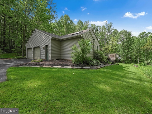 320 N Ridge Rd, Reinholds, PA 17569 - view of side of home with asphalt driveway, an attached garage, a lawn, and a wooden deck