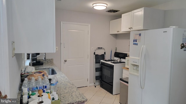 15030 Alabama Ave, Woodbridge, VA 22191 - kitchen featuring white refrigerator with ice dispenser, gas range, white cabinets, light tile patterned floors, and a sink