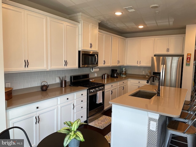 kitchen with stainless steel appliances, a sink, white cabinetry, and recessed lighting