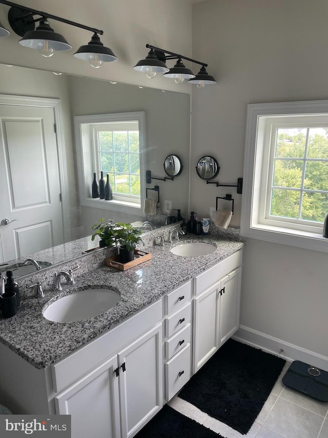 full bathroom featuring tile patterned floors, double vanity, and baseboards