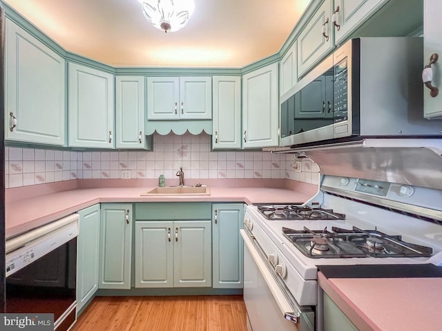 12419 Balston Rd, Philadelphia, PA 19154 - kitchen featuring white gas stove, a sink, dishwasher, stainless steel microwave, and light wood finished floors