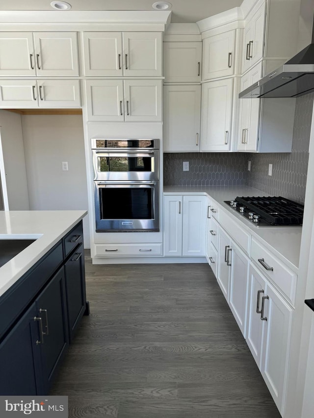 505 Trifecta Rd Unit 373, Downingtown, PA 19335 - kitchen with wall chimney range hood, white cabinetry, stainless steel appliances, light countertops, and dark wood-style flooring