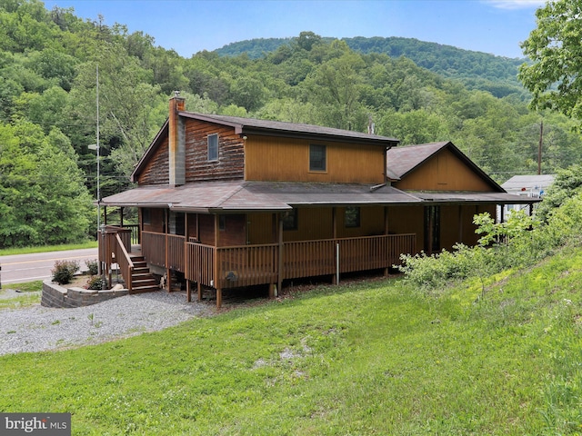 12417 Mount Savage Rd, Mount Savage, MD 21545 - back of property featuring a forest view, a chimney, covered porch, and a lawn