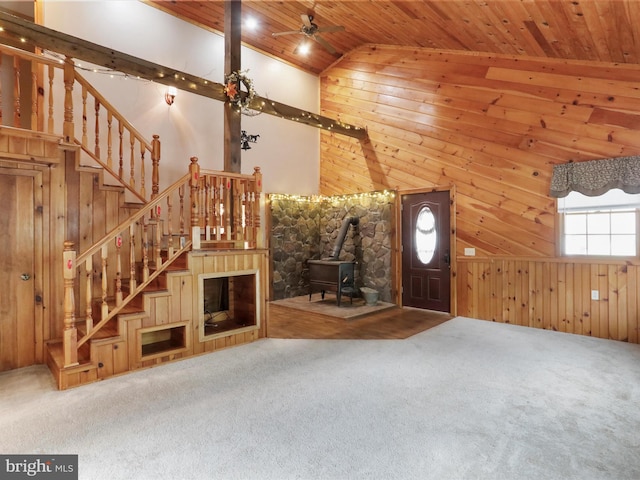 12417 Mount Savage Rd, Mount Savage, MD 21545 - unfurnished living room with wooden ceiling, a wood stove, carpet flooring, stairway, and wood walls