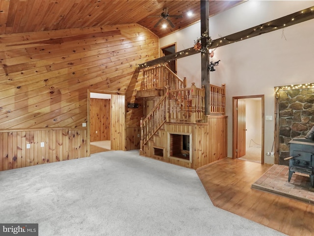 12417 Mount Savage Rd, Mount Savage, MD 21545 - unfurnished living room featuring a wood stove, wooden ceiling, high vaulted ceiling, wood walls, and carpet flooring
