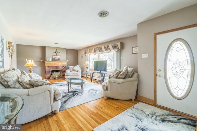 1143 Villanova Ave, Swarthmore, PA 19081 - living room featuring wood finished floors, a fireplace, and a baseboard radiator