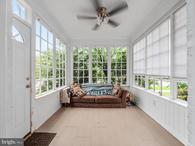 sunroom / solarium featuring ceiling fan and crown molding