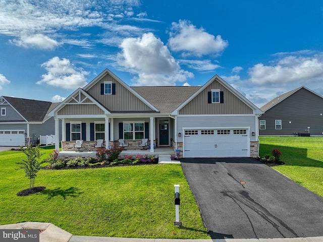 craftsman house featuring board and batten siding, a porch, asphalt driveway, and stone siding