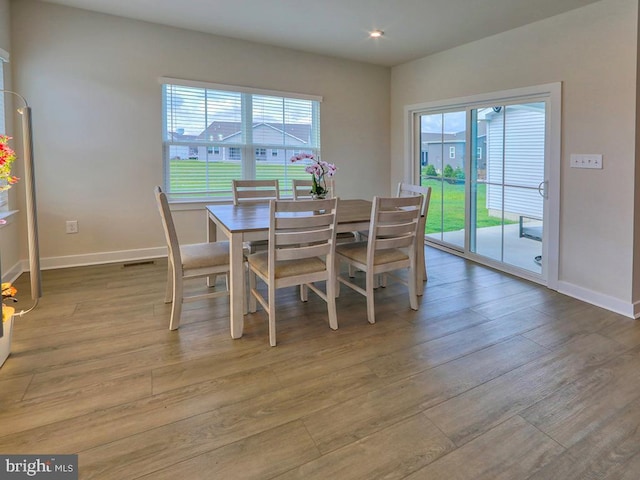 dining space featuring healthy amount of natural light, wood finished floors, baseboards, and recessed lighting