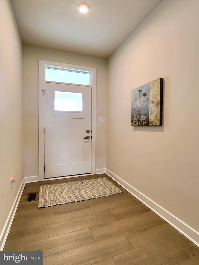 entryway featuring baseboards and wood finished floors