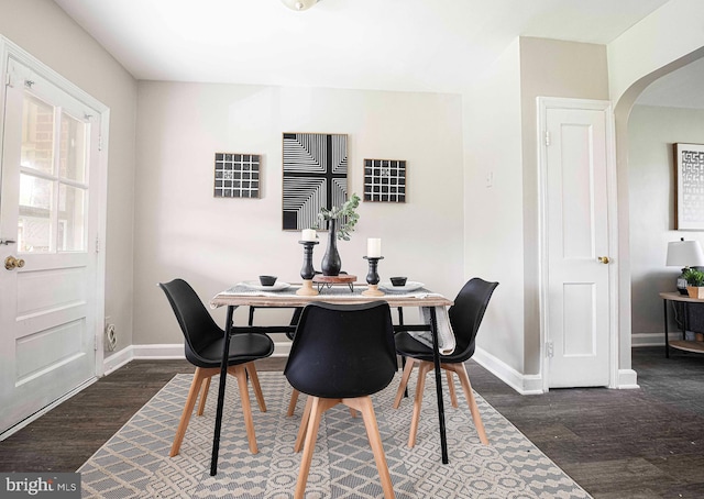 3565 Benzinger Rd, Baltimore, MD 21229 - dining area featuring dark wood-style flooring, baseboards, and arched walkways
