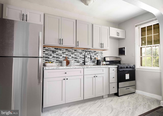 3565 Benzinger Rd, Baltimore, MD 21229 - kitchen featuring stainless steel appliances, baseboards, light marble finish flooring, a sink, and decorative backsplash