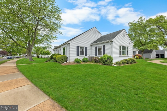 view of front facade with a front yard and a shingled roof