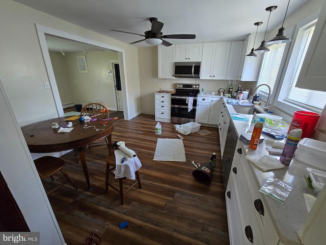 26689 Mariners Rd, Crisfield, MD 21817 - kitchen with stainless steel appliances, a sink, dark wood-style floors, a ceiling fan, and white cabinets
