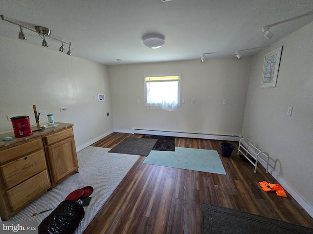 26689 Mariners Rd, Crisfield, MD 21817 - spare room featuring rail lighting, baseboard heating, dark wood-style flooring, and baseboards