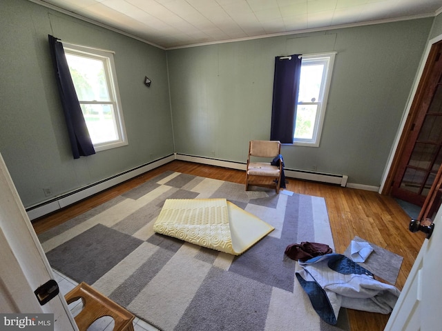 26689 Mariners Rd, Crisfield, MD 21817 - living area featuring a baseboard radiator, wood finished floors, crown molding, and baseboards