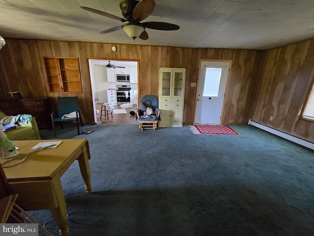 26689 Mariners Rd, Crisfield, MD 21817 - carpeted living area with wooden walls, a ceiling fan, and a baseboard heating unit